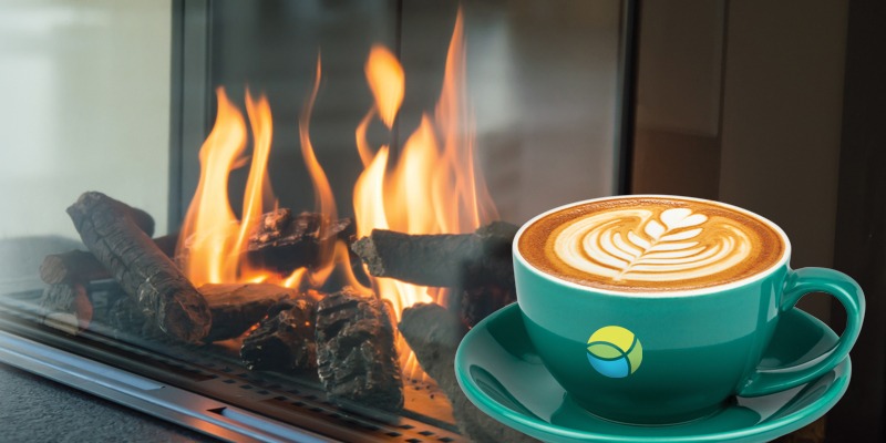 Fireplace with fire and cappuccino in green mug